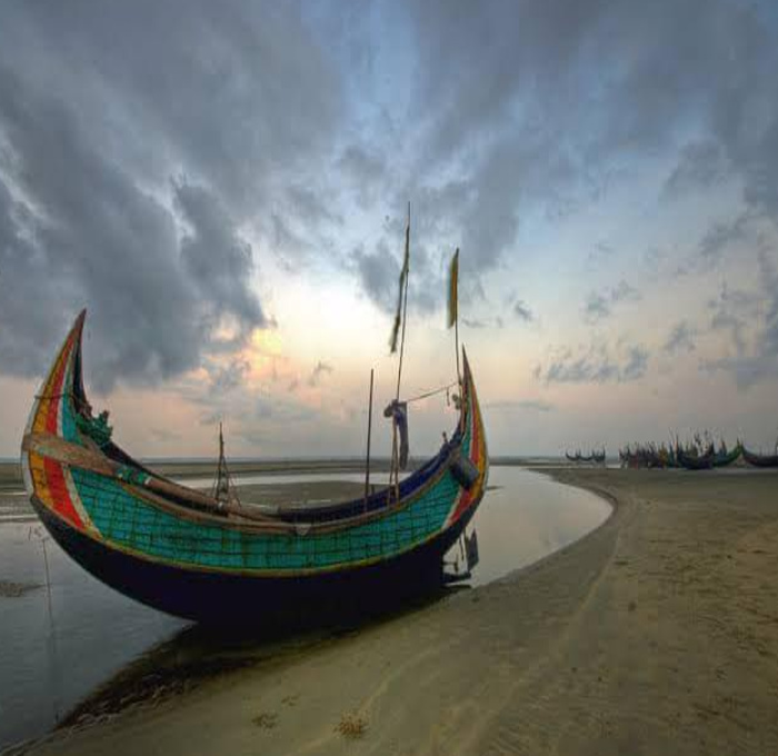 A boat stands at Inani Beach under the cloudy sky