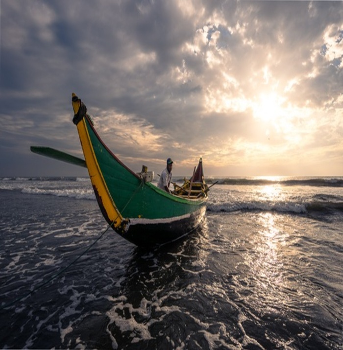 A man in a boat with a stunning sunny view at teknaf beach